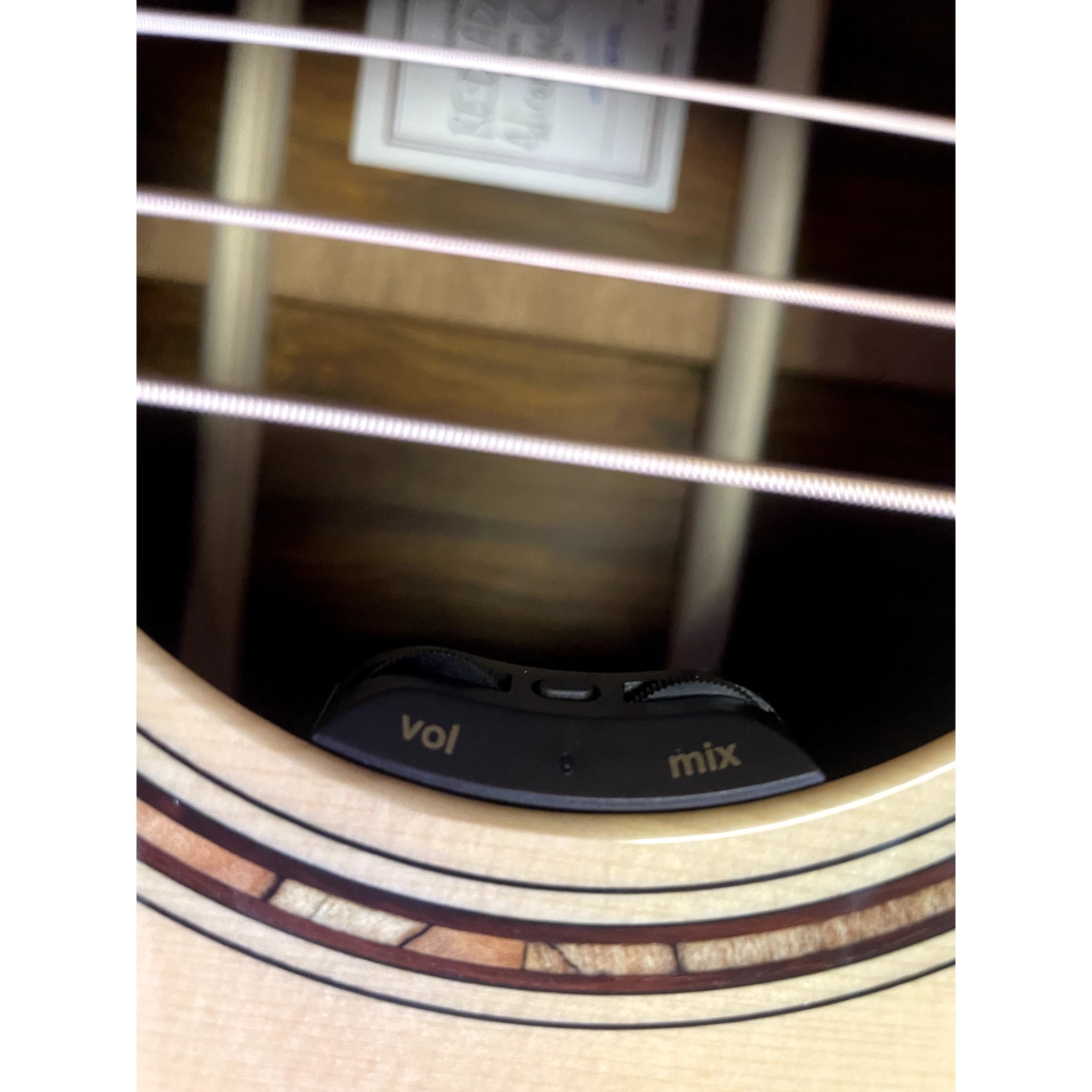 Close-up of an acoustic guitar's soundhole with a 'VOI' and 'mix' label.
