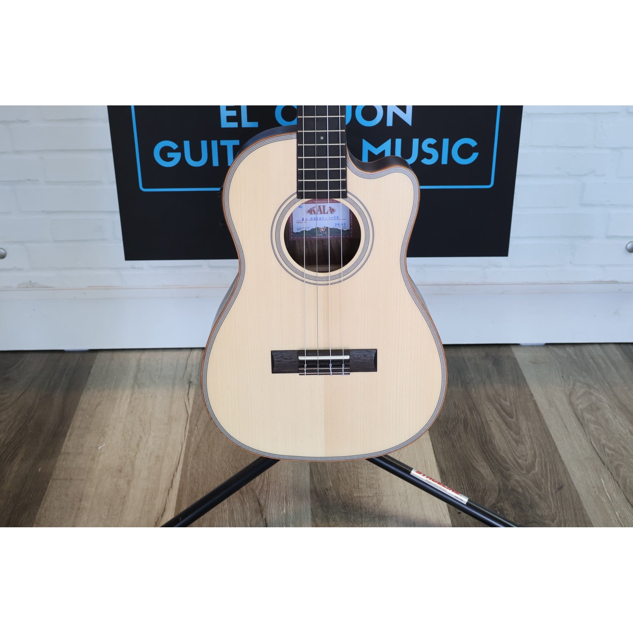 Kala KA-SSEBY-B-CE Solid Spruce Striped Ebony Baritone Acoustic-Electric Ukulele with a natural wood finish and black hardware, displayed at ECG Music shop.