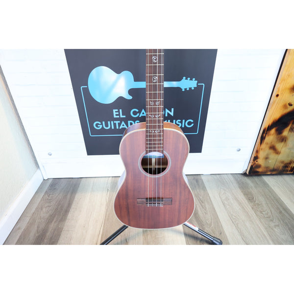 A A Kala KA-SA-B All-Solid Acacia Baritone Ukulele with a reddish-brown finish stands on a stand at ECGMusic with the body and grain showing.