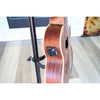Close-up of the side of Close-up of a A Kala KA-SA-TE-C All-Solid Acacia Tenor Cutaway Ukulele with Fishman Electronics showing the body wood finish, sound hole, strings, and a black control panel with knobs.