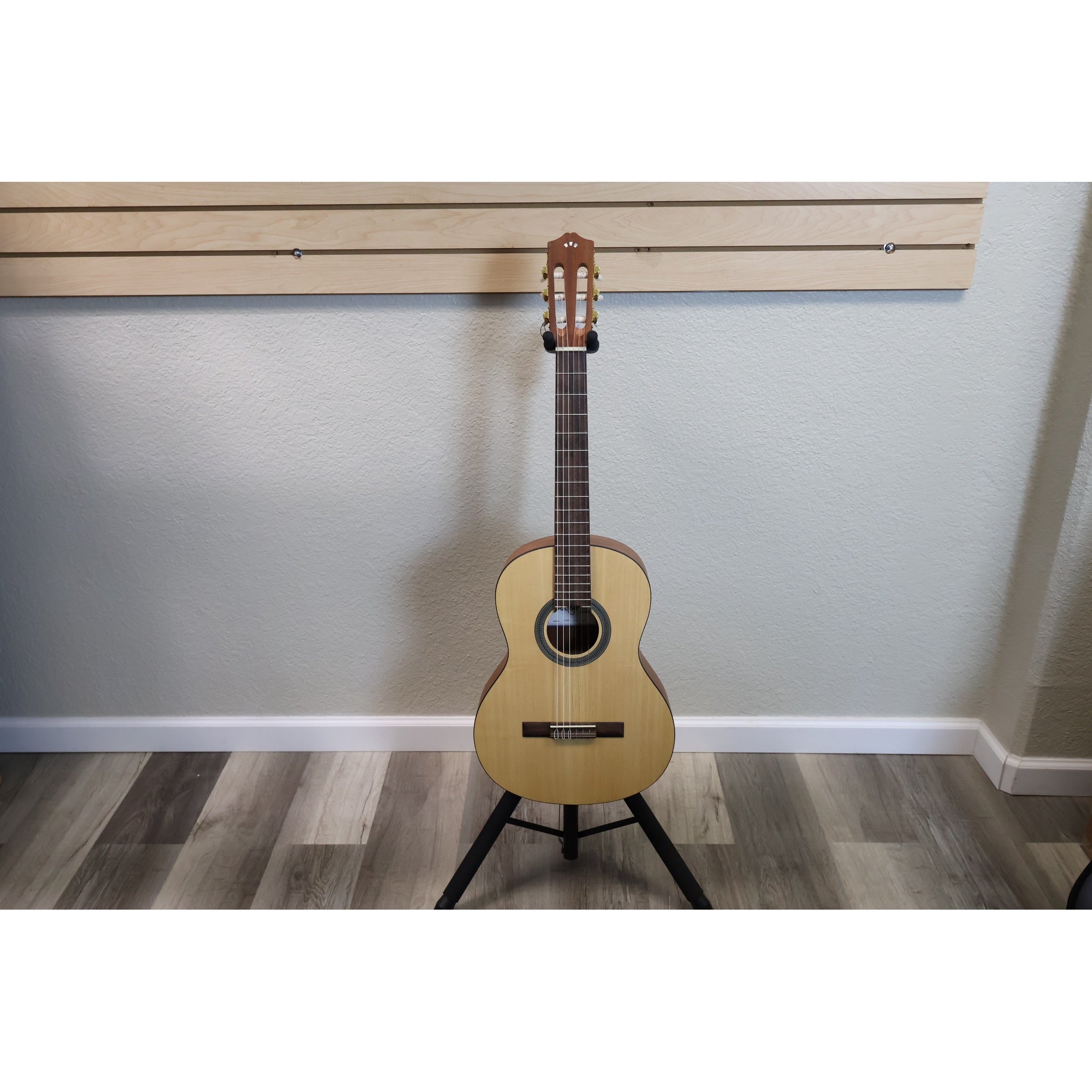 Protégé by Córdoba C1M 3/4 classical guitar in natural finish, full front view on a guitar stand