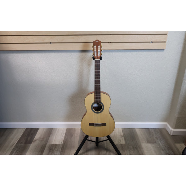 Protégé by Córdoba C1M 3/4 classical guitar in natural finish, full front view on a guitar stand