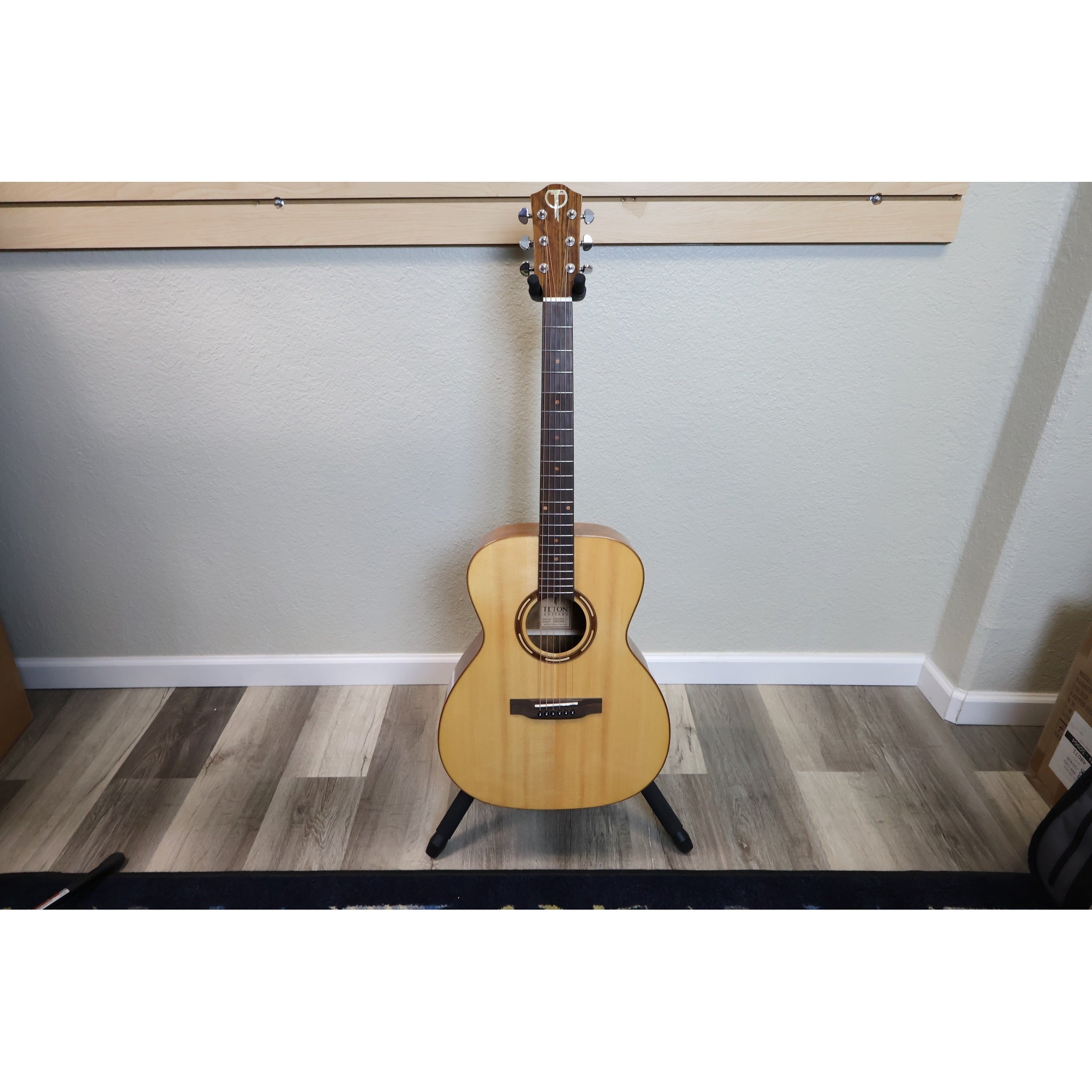 Teton STG110NT grand concert acoustic guitar on stand at El Cajon Guitars & Music, front view