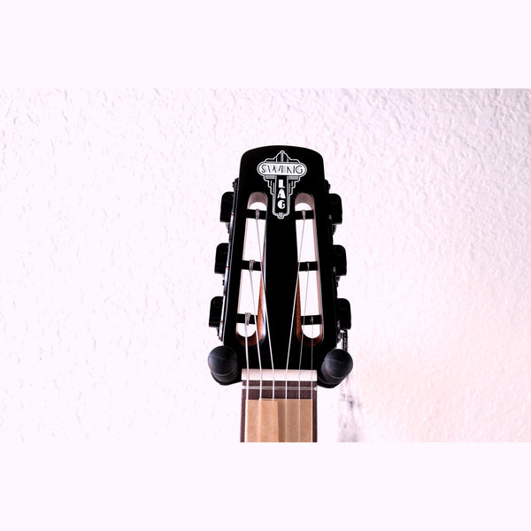 Close-up of the front guitar headstock of the Lâg SL100 Petite Bouche Gypsy Jazz Guitar featuring black tuning pegs, and a light wood fretboard, with "Swing, Lâg" showing on the headstock.