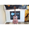 A A Kala KA-SA-B All-Solid Acacia Baritone Ukulele with a reddish-brown finish stands on a stand in front of a white paneled wall with a black sign that reads 'Eaton Guitar Music.