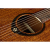 Close-up of an LAG T98PE Tramontane 98 Parlor Acoustic-Electric Guitar showing the sound hole, wood grain, strings, and part of the fretboard against a white background.