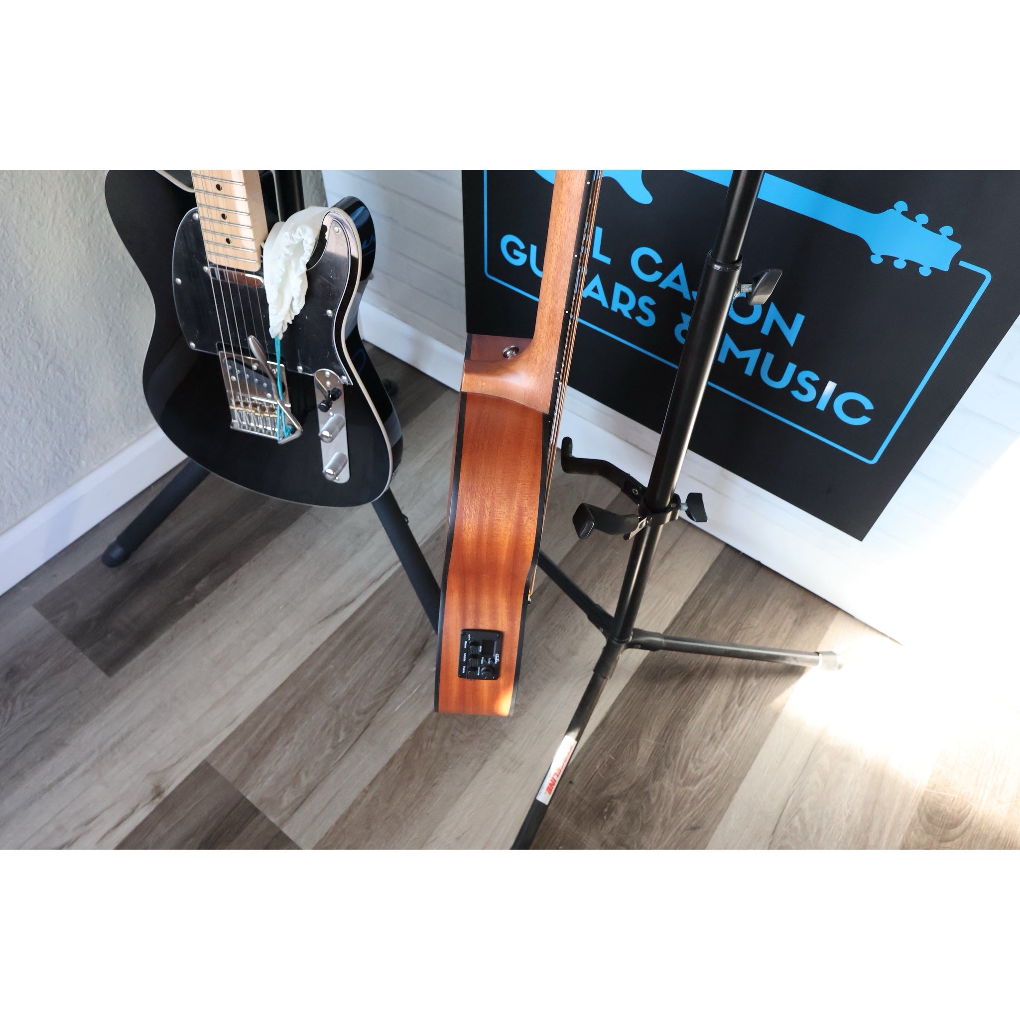 Córdoba Mini II Bass MH-E next to a full-size electric guitar, size comparison