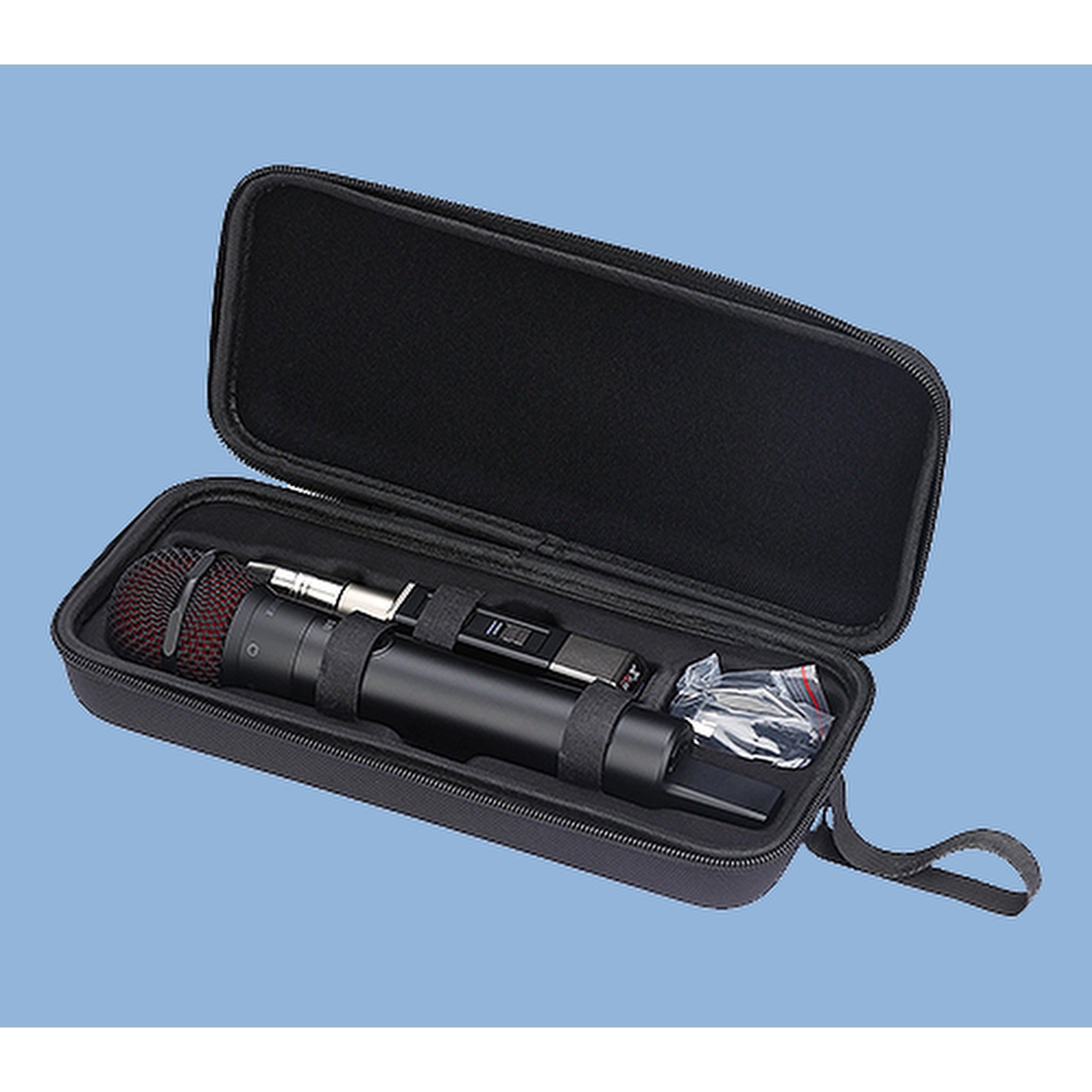 A black handheld microphone inside an open black zippered hard carrying case, with a small plastic-wrapped accessory and strap visible, set against a light blue background.