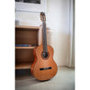 Córdoba C5 CD Acoustic guitar leaning against a white wall with a shelf in the background