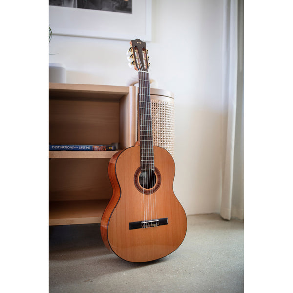 Córdoba C5 CD Acoustic guitar leaning against a white wall with a shelf in the background