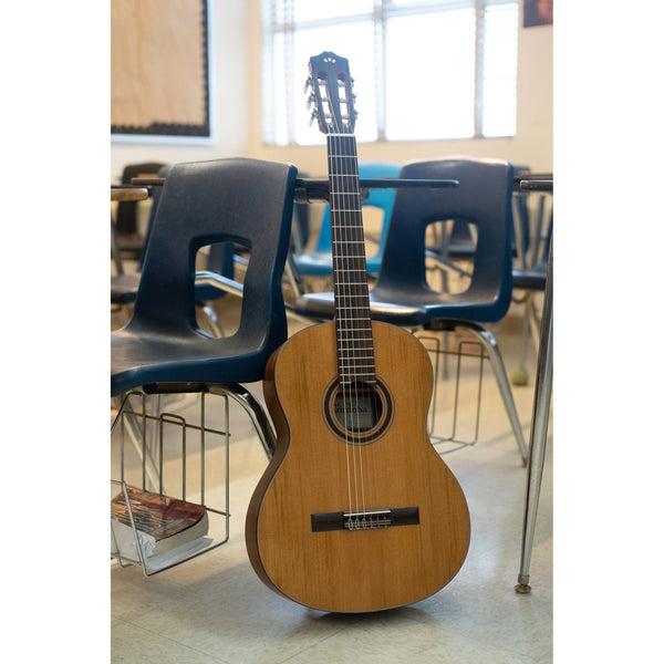 Córdoba C3M solid Acoustic guitar leaning against a chair in a classroom setting