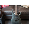 Electric guitar on a brown leather couch with a box in the background