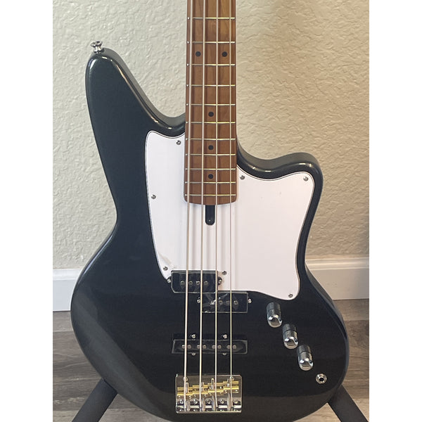 Ashdown Black electric bass guitar with a white pickguard on a wooden floor.