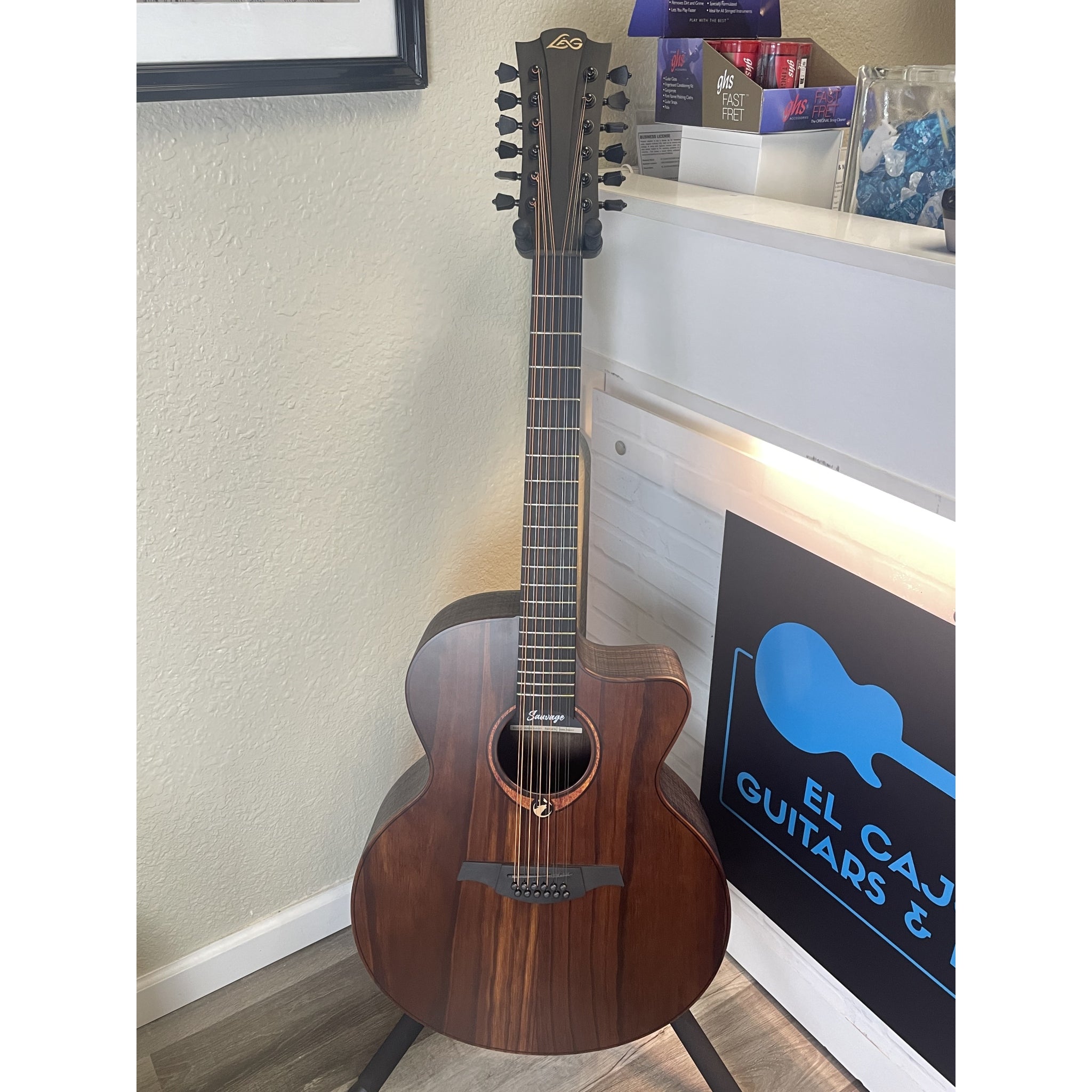 12 string Acoustic Electric guitar leaning against a wall with a store sign in the background