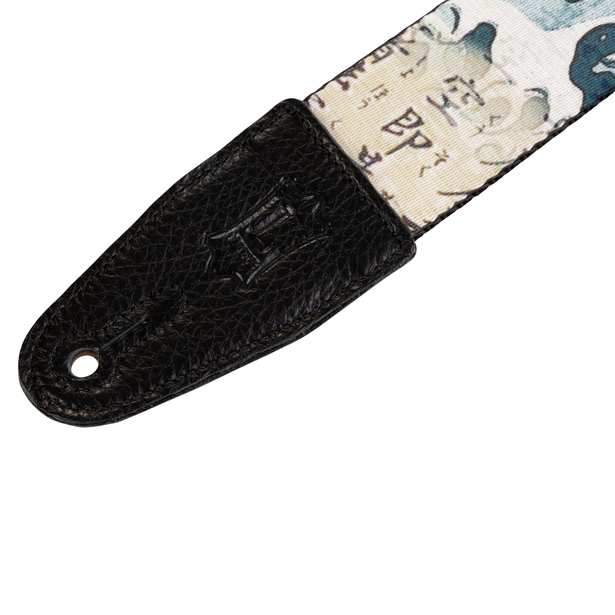 Guitar strap with black leather end and patterned fabric on a white background
