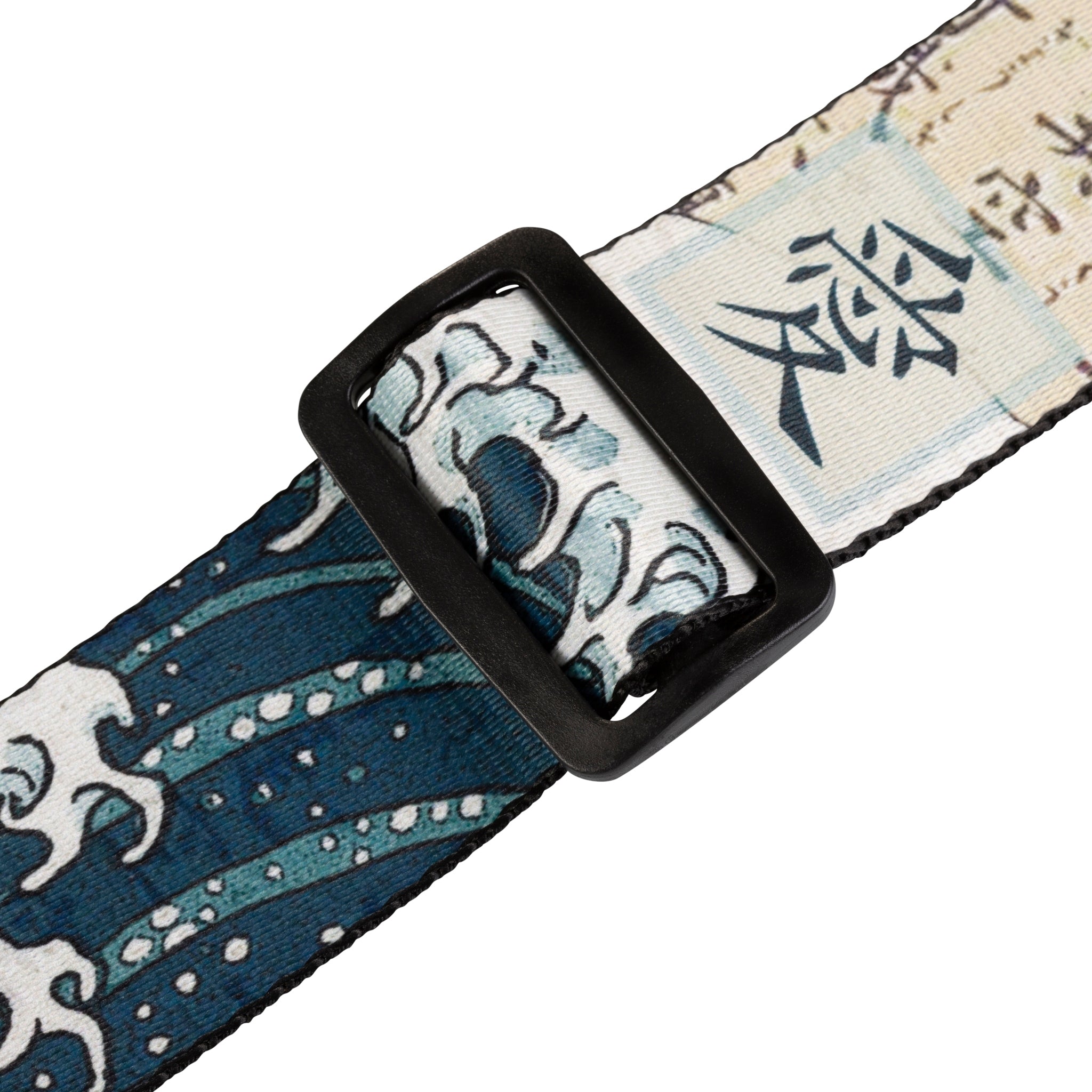 Fabric strap with black buckle featuring blue and white wave design on a white background