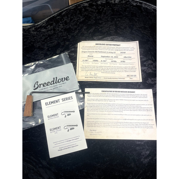 Guitar case with Breedlove branding and documents on a black background