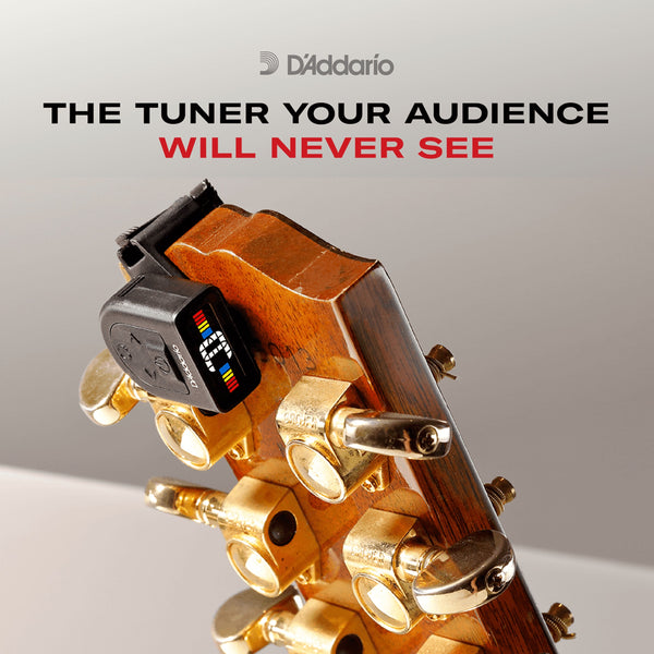 A close-up of a guitar headstock with gold tuning pegs and a black D'Addario clip-on tuner attached, set against a light gray background with promotional text reading 'THE TUNER YOUR AUDIENCE WILL NEVER SEE' and the D'Addario logo.