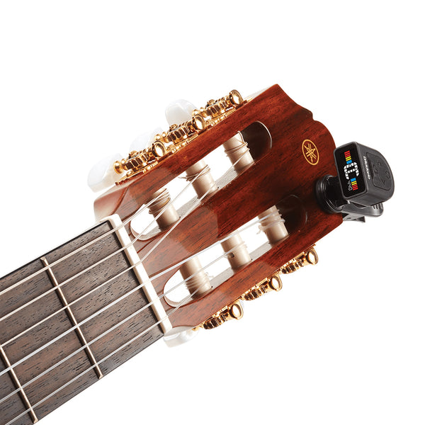 Guitar headstock with a digital tuner on a white background with D'Addario PW-CT-13 Micro Universal Guitar Tuner.