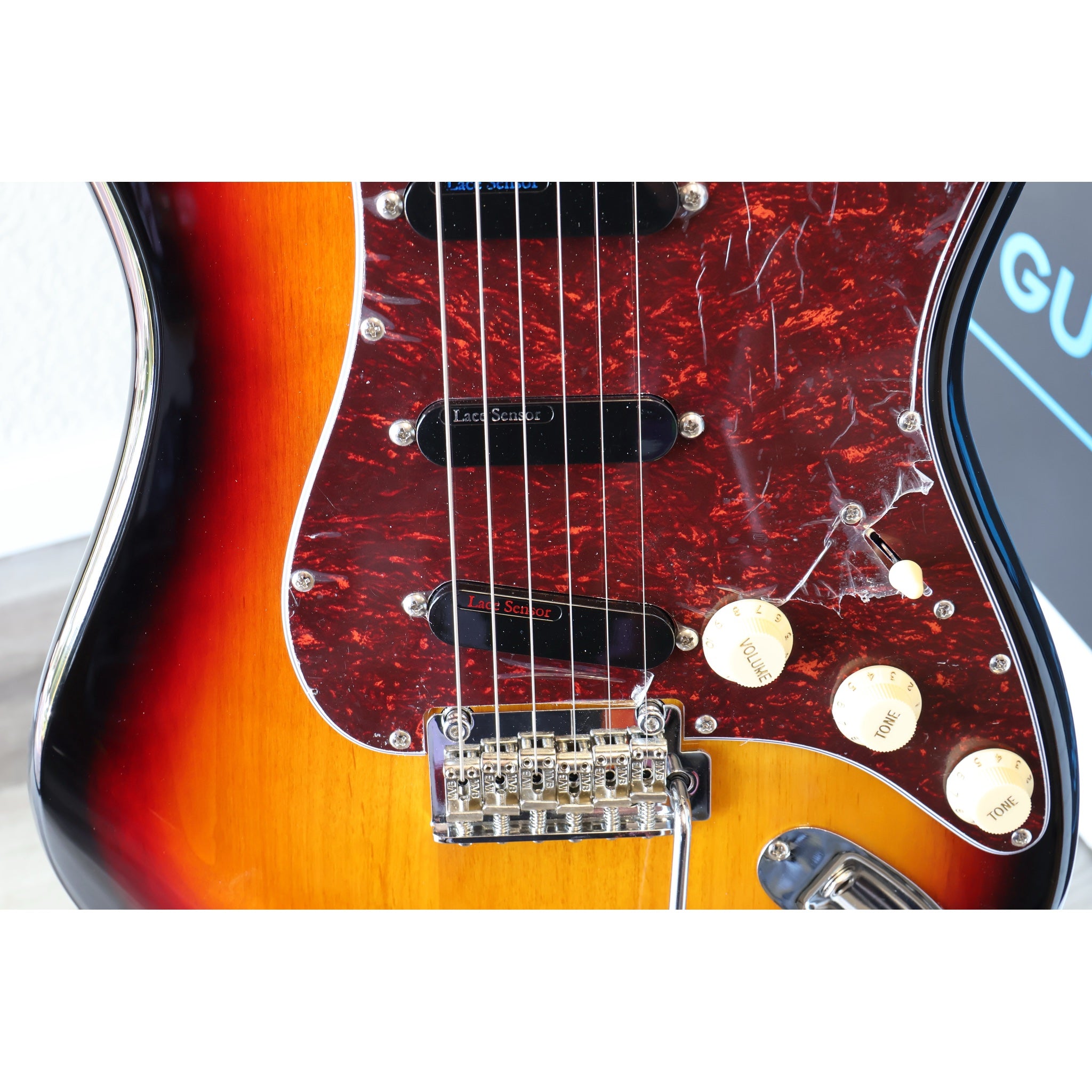 Close-up of a Fender electric guitar with a sunburst finish.