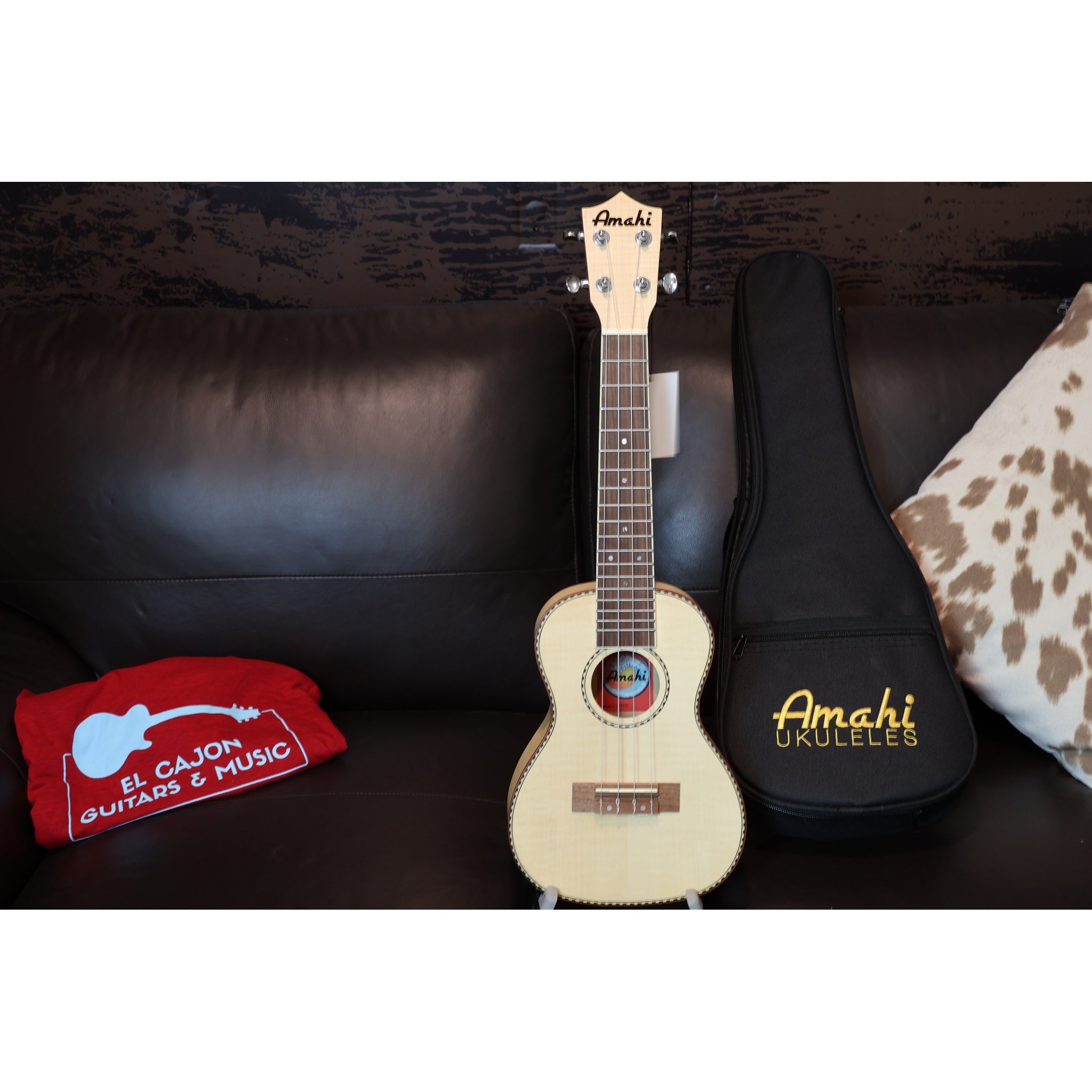 Amahi ukulele with a case on a dark surface