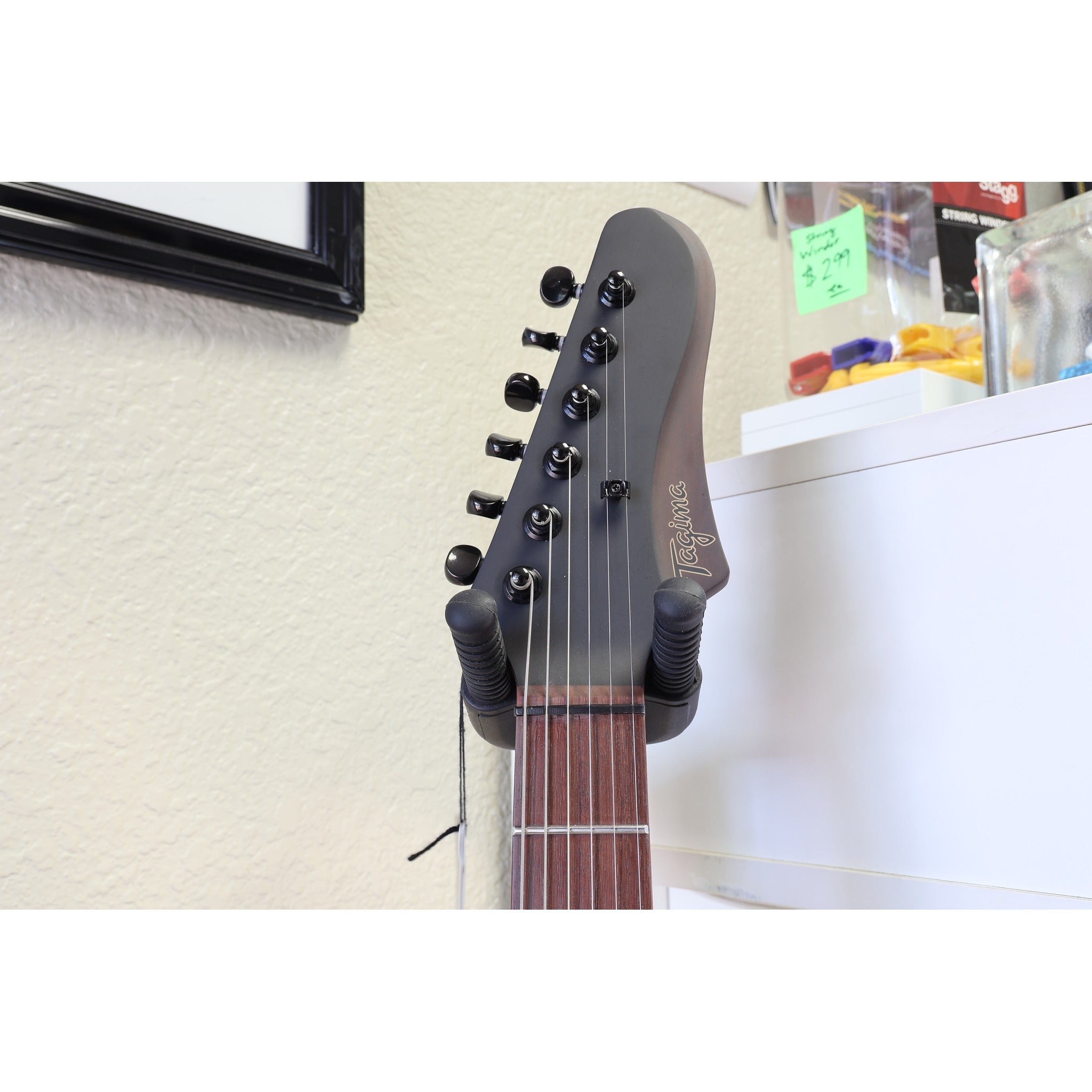 Black single-ply pickguard and control knobs on the Tagima Rocker Cosmos Stealth guitar