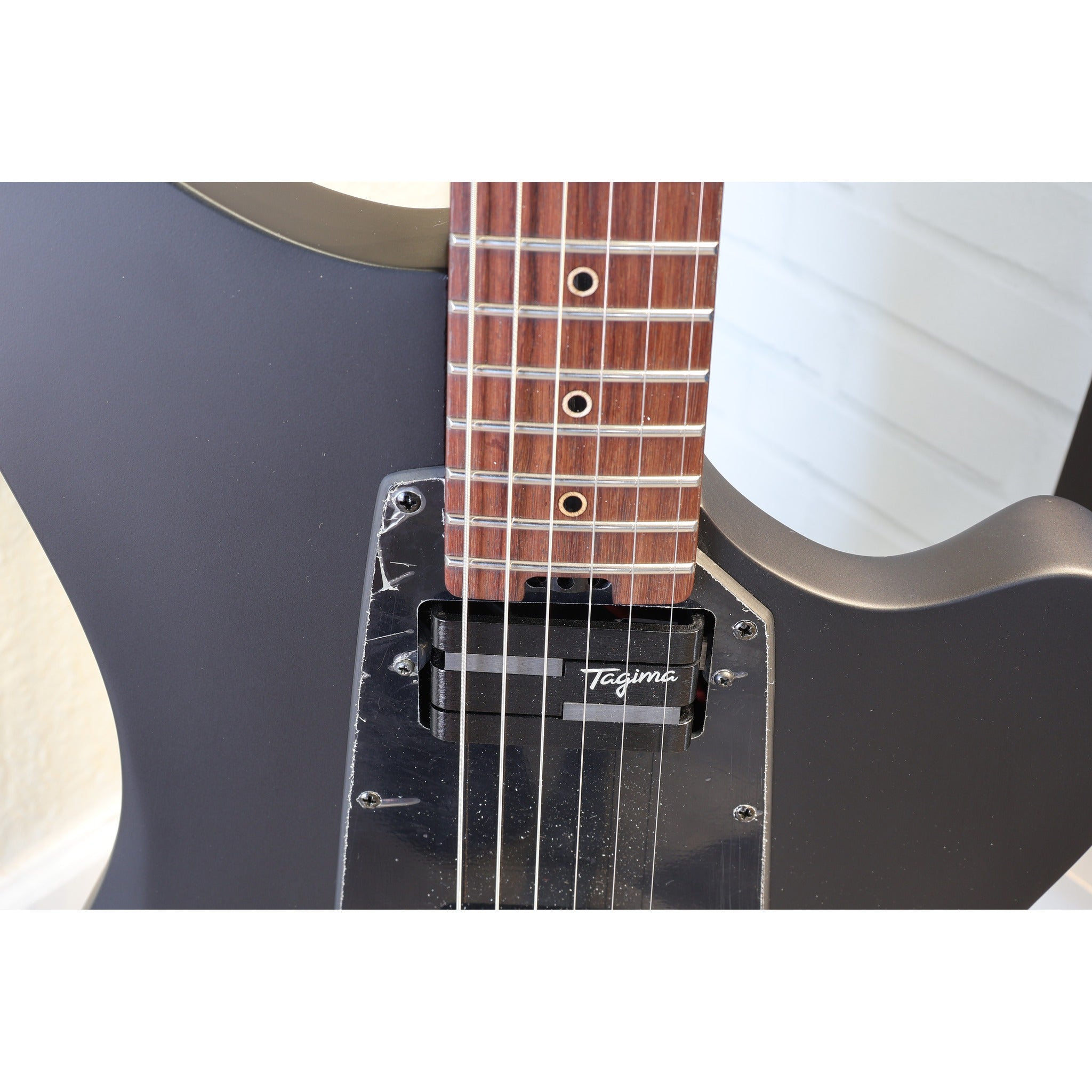 Tagima Rocker Cosmos Stealth electric guitar angled studio shot showing full offset silhouette with custom Lace Pickups.