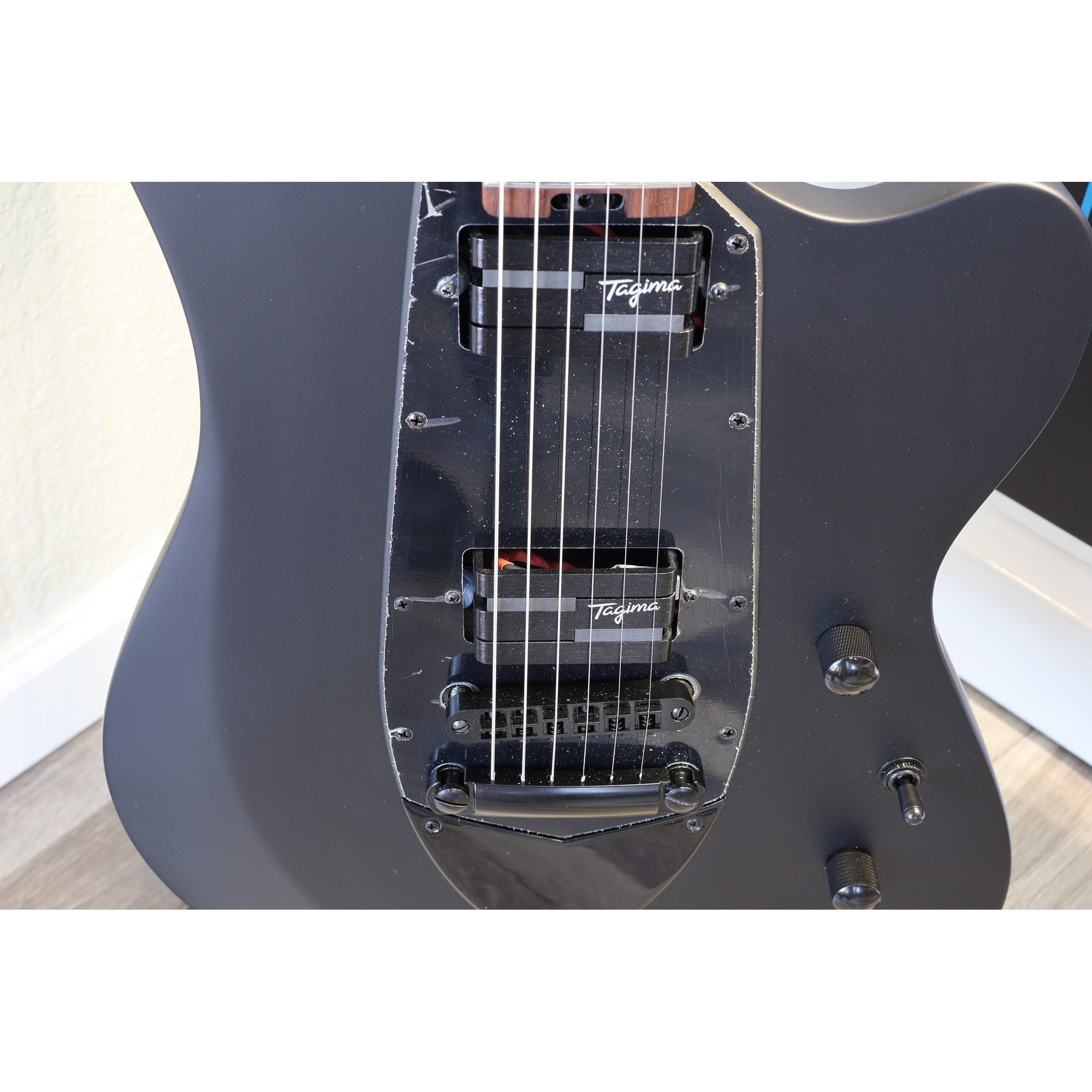 Black locking tuner detail on the Tagima Rocker Cosmos Stealth guitar headstock
