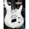 White electric guitar with black details held by a person, with a blurred background.
