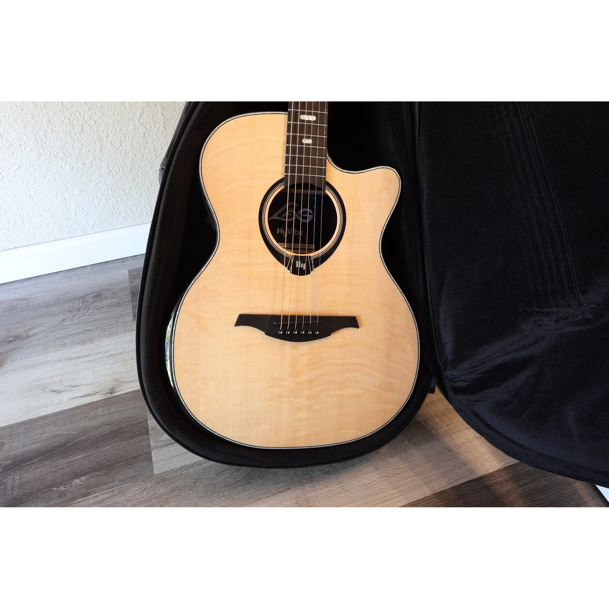 Lâg HyVibe 50 Auditorium Bevel Cutaway Smart Guitar – HV50ACE-2604LT07464 in case with face of guitar showing.