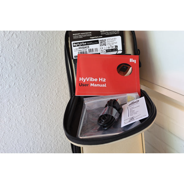 Lâg HyVibe 50 Auditorium Bevel Cutaway Smart Guitar – HV50ACE-2604LT07464 with warranty card, serial number, upc, HyVibe H2 user Manual, USB charging cable, Truss Rod Adjustment tool, and Quality Control checklist.