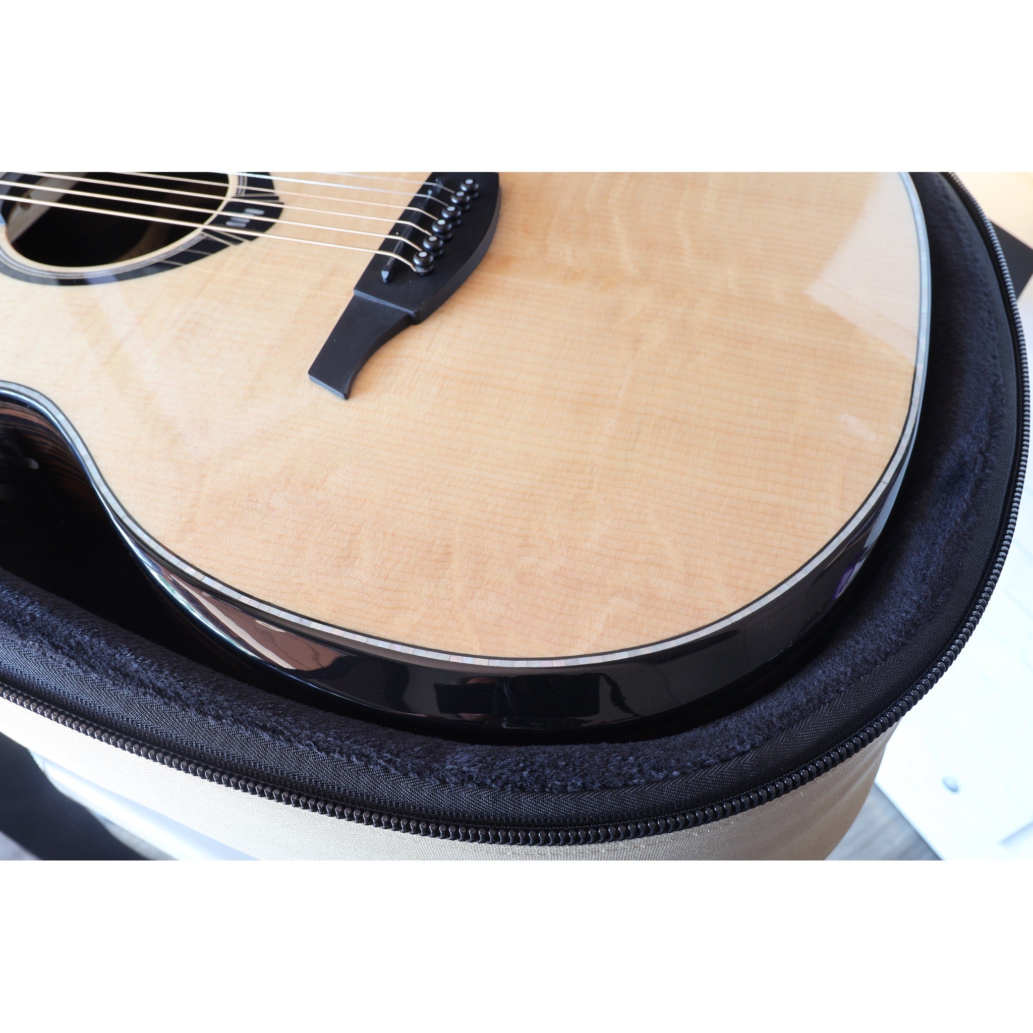 Lâg HyVibe 50 Auditorium Bevel Cutaway Smart Guitar – HV50ACE-2604LT07464 lower bout in case with edge and grain detail showing.