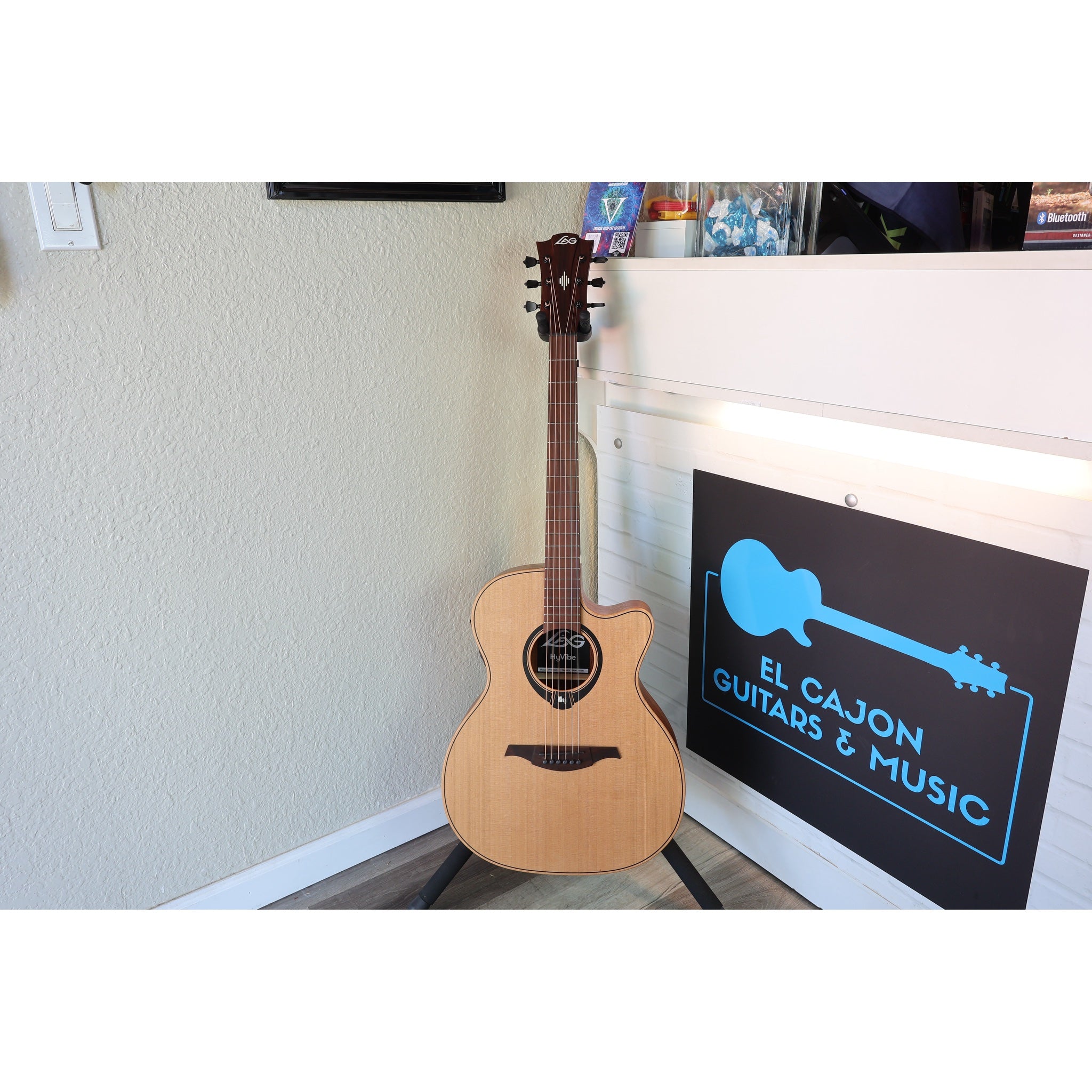 This Lâg HyVibe 10 HV10ACE, Serial Number 2604LT07360, in a stand in the front corner at El Cajon Gutiars & Music, ECGMusic.com