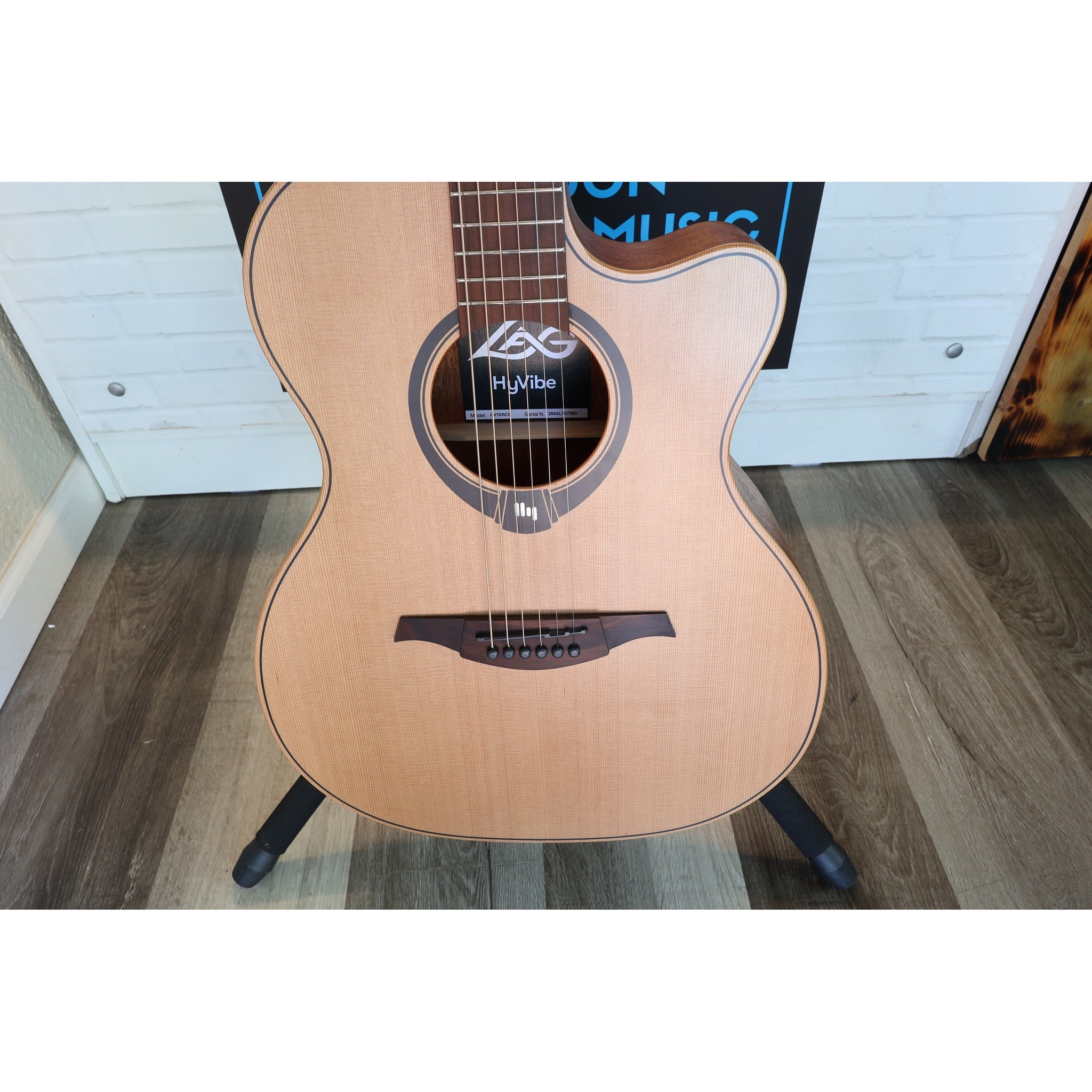 Front view of the body on this Lâg HyVibe 10 HV10ACE Serial 2604LT07360 in a stand at ECG Music.
