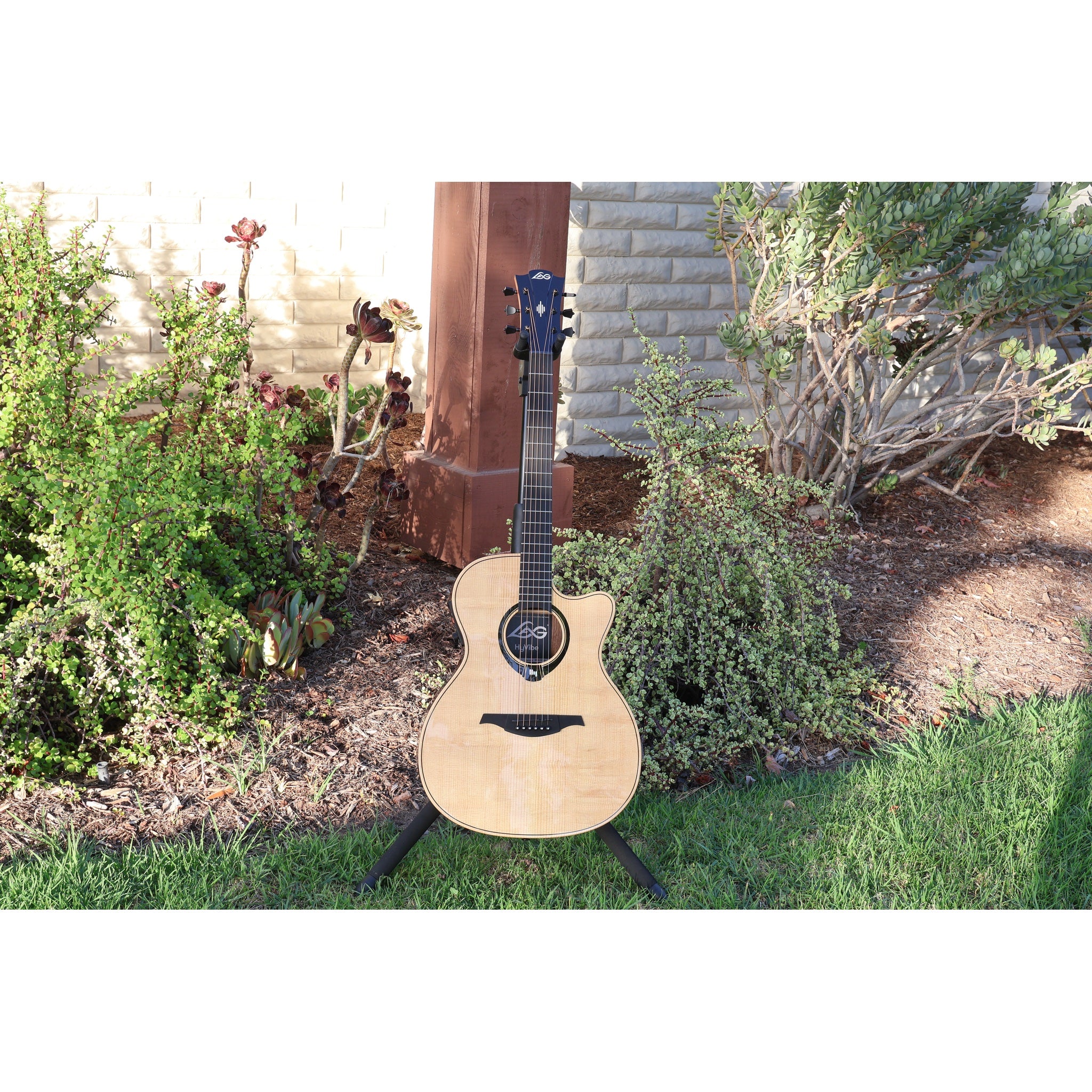 Lag Smart Guitar Hyvibe 30 Auditorium Cutaway Gloss at ECG Music - front full acoustic guitar in stand at ECGMusic outside