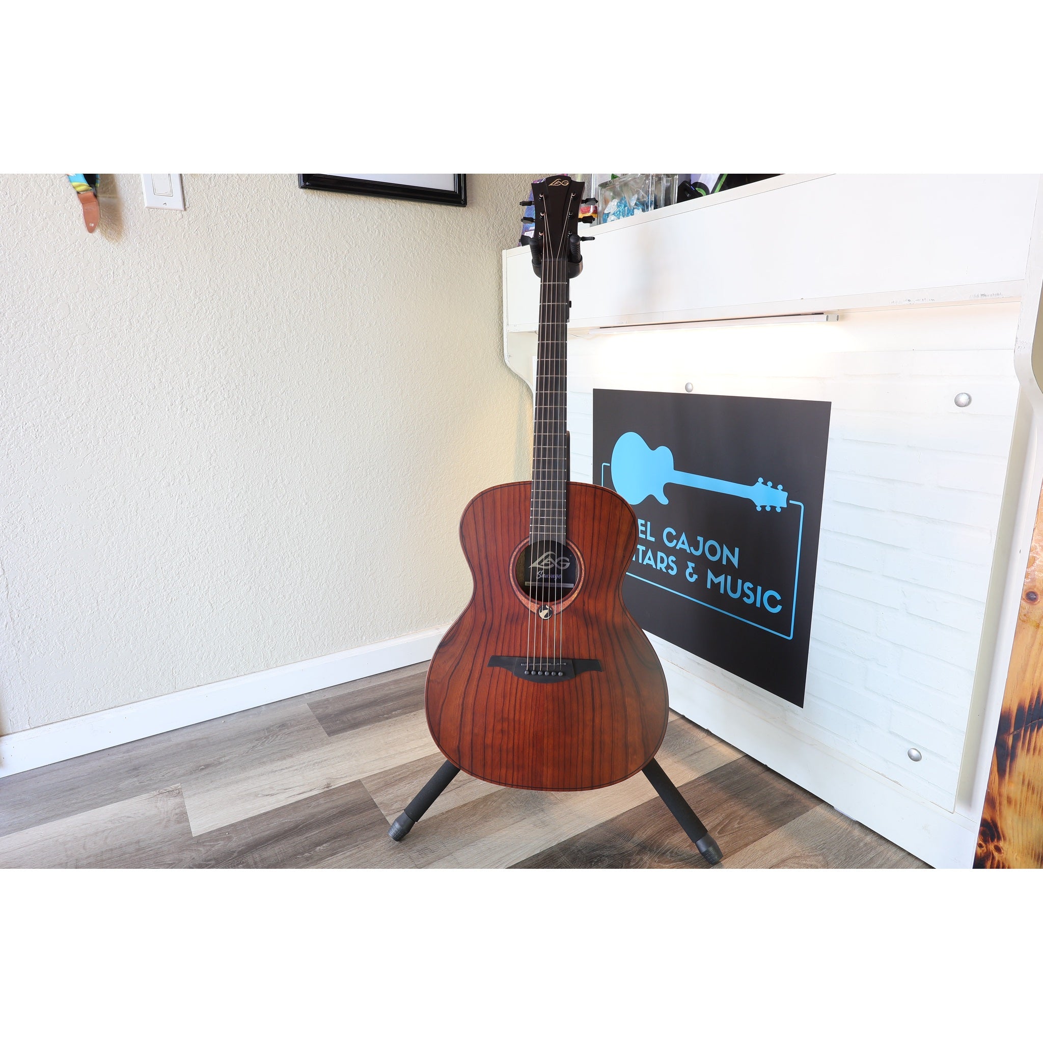 This guitar, the Lâg Sauvage-A Auditorium Acoustic Guitar with Serial 2511LT20951, in a stand at the from of ECG Music.