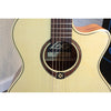 Close-up of a Takamine acoustic guitar body and neck, showing the natural wood grain, soundhole rosette, and brand logo.