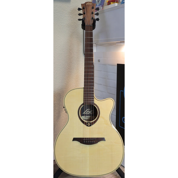 Lâg Tramontane T88ACE Auditorium Cutaway Acoustic-Electric Guitar with a natural wood finish and a dark neck, photographed against an indoor wall background.