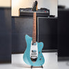 Tagima Rocker UQ Lake Placid Blue on a stand in front of an amp