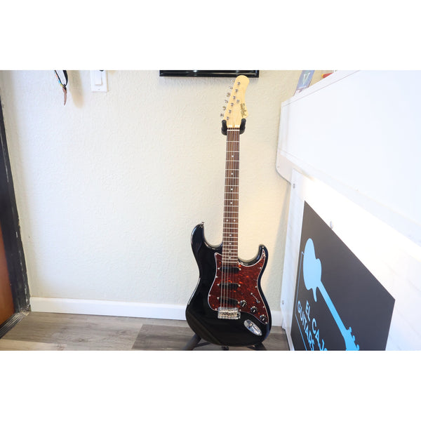 Tagima T-635 Classic Black Electric Guitar with Lace Sensor Pickups in a stand at El Cajon Guitars & Music.