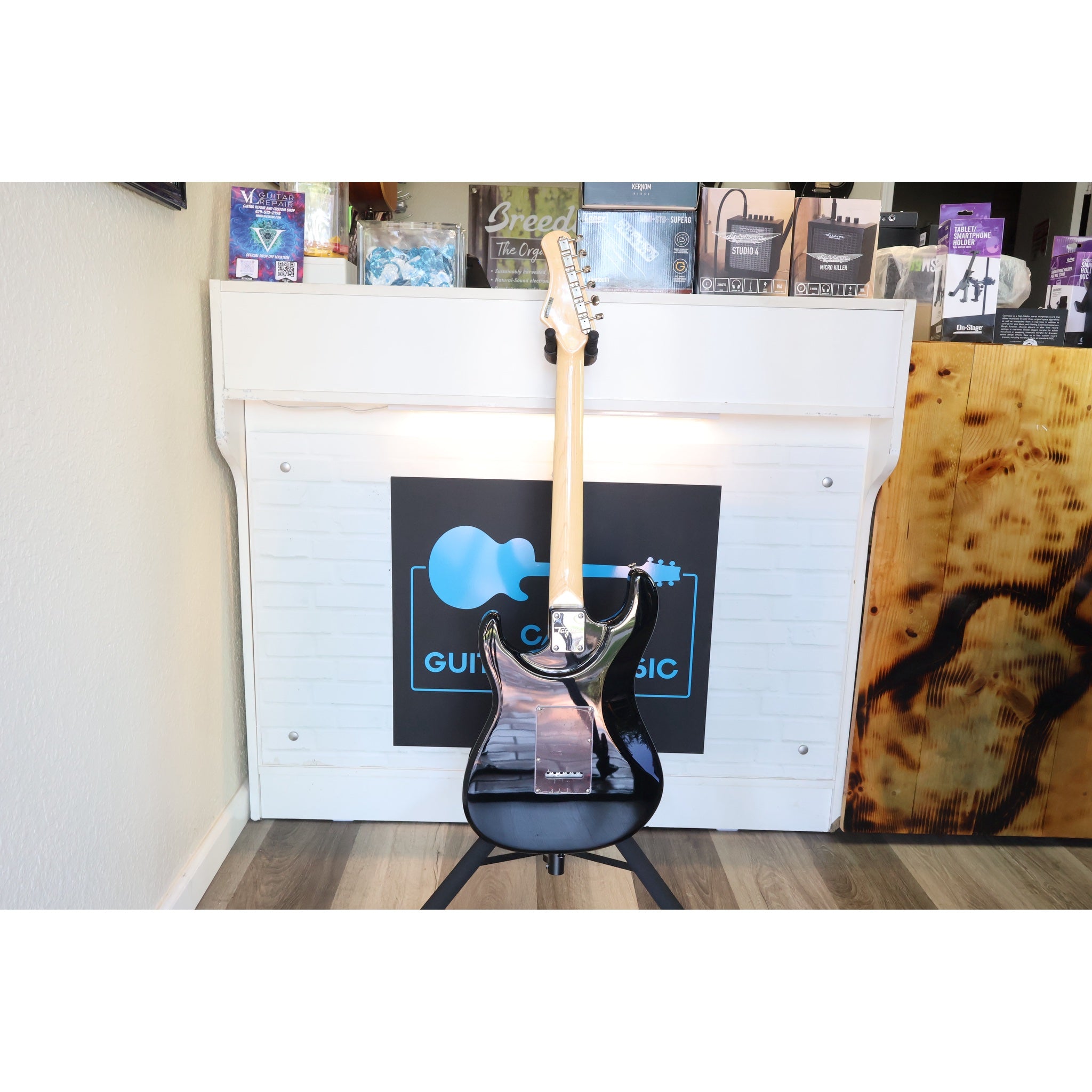 Back view of this electric guitar in a stand at ECG Music showing El Cajon Guitars & Music logo.