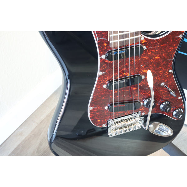 Closeup of the Tagima T-635 Classic Black Electric Guitar showing the Lace Sensor Red/Silver/Blue Pickups, the trem bar control knobs, selector switch, output jack., and pickguard.
